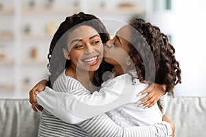 Loving african american school girl kissing her mother