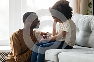 Loving african dad comforting crying kid daughter showing empathy