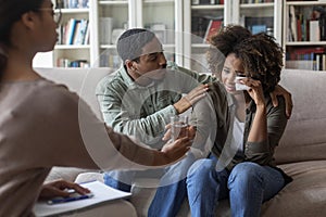 Loving african man comforting crying wife while having family therapy