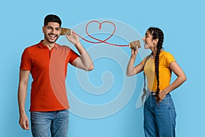 Loving Arab Woman Telling Romantic Words To Boyfriend Through Tin Can Phone