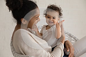 Loving biracial mom embrace play with little baby child