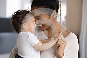 Loving biracial mom hug cute little baby child