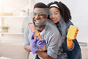 Loving Black Couple Cleaning Flat Together, Embracing And Posing To Camera