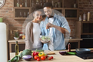 Loving black couple cooking green healthy salad