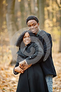 Loving black couple walking in park and enjoying autumn day