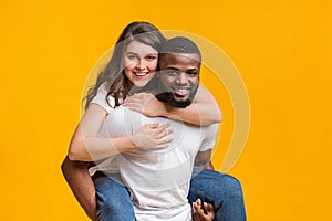 Loving black guy carrying his girlfriend on his back