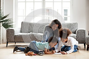 Loving black mom and little children drawing with colored pencil photo