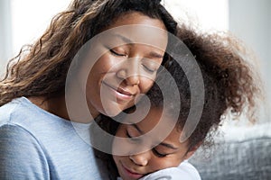 Loving black mother embrace little preschool daughter