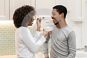 Loving black woman feeding her handsome boyfriend, have breakfast together