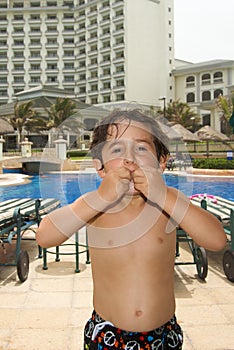 Loving boy sending kisses next to swimming pool