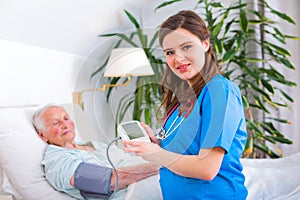 Loving caregiver measuring blood pressure