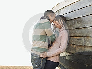 Loving Couple Against Wooden Hull Of Boat