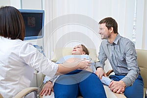 Loving couple attending doctor for pregnancy ultra sound procedu