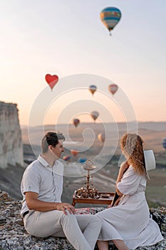 A loving couple among the balloons. A couple in love in Cappadocia. Couple in Turkey. Honeymoon in the mountains.