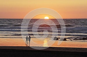 Loving couple in the beach watching sunset