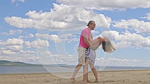 Loving couple on the coast, dancing. This is their love story. They hug and kiss. A man and a woman are happy and joyful