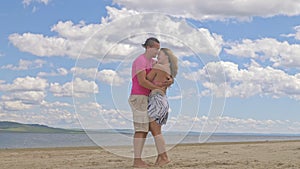 Loving couple on the coast, dancing. This is their love story. They hug and kiss. A man and a woman are happy and joyful