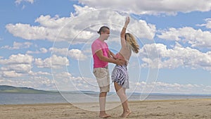 Loving couple on the coast, dancing. This is their love story. They hug and kiss. A man and a woman are happy and joyful