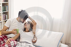 Loving couple drinking coffee in bed