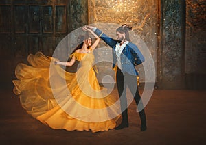 loving couple is dancing at fairy ball. Happy beauty woman fantasy princess in yellow dress and guy is enchanted beast photo