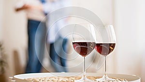 Loving couple dancing with glasses of red wine on foreground