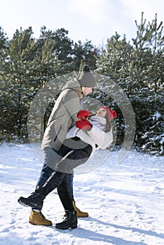 Loving couple dancing in winter forest. Frosty clear day. Vertical frame