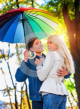 Loving couple on date under umbrella. Sun after rain.