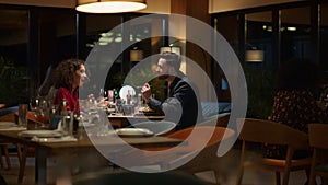 Loving couple eating together in restaurant. Two people share dinner date food.
