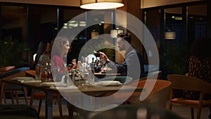 Loving couple eating together in restaurant. Two people share dinner date food.