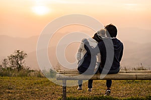 Loving couple embracing on the mountain at sunset.