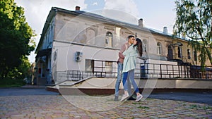 Loving couple embracing in the sun. Against the background of an old building