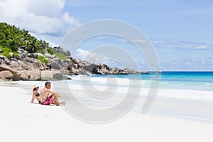 Loving couple enjoy their vacation together at tropical beach in Seychelles.