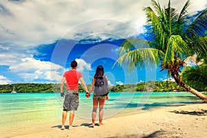 A loving couple enjoying the breathtaking views of the tropical sandy beach