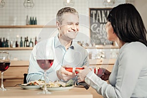 Loving couple exchanging presents at restaurant