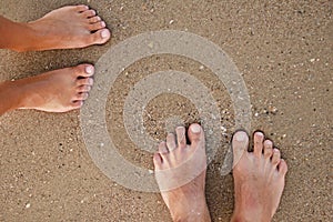 Loving couple feet in the sand