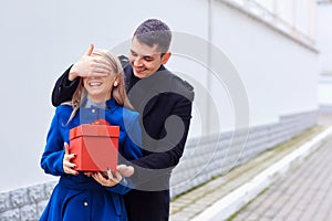 A loving couple gives a gift in a box.