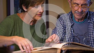 Loving couple of grandparents look at their old wedding photo album.Loving couple of grandparents look at their old wedding photo