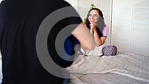 Loving couple with guitar sitting on bed. Man playing blue acoustic guitar while sitting on bed for your girlfriend