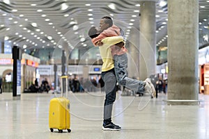 Loving couple happy meeting after long time. African man and woman excited hug in airport terminal