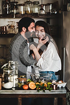 Loving couple having fun during cooking together in kitchen