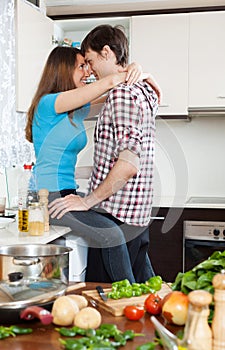 Loving couple having sex at table in kitchen