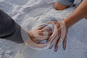 Loving couple holding hands on the sand