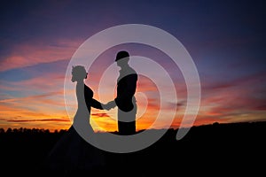 Loving couple holding hands at sunset