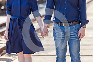 Loving couple holding hands while walking outdoors. Couple holding the hands together at outdoors. Hands and hearts together.