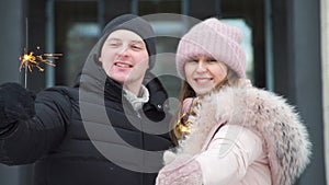 Loving Couple Holding a Sparklers in Winter day