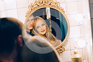 Loving couple hugging in the bathroom mirror. Lifestyle couples loving each other.