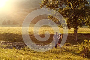 Loving couple hugging, honeymoon in the mountains, the landscape, the warm colours of the setting sun, backlight, mountains, summe