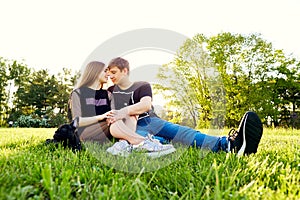 A loving couple hugging sitting on the grass in the park