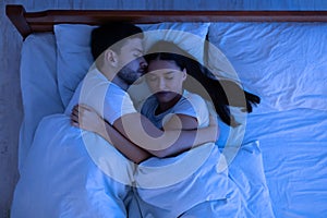 Loving Couple Hugging Sleeping In Bed At Home, Above View