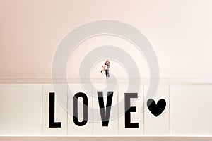 Loving couple hugging on top of a large LOVE sign